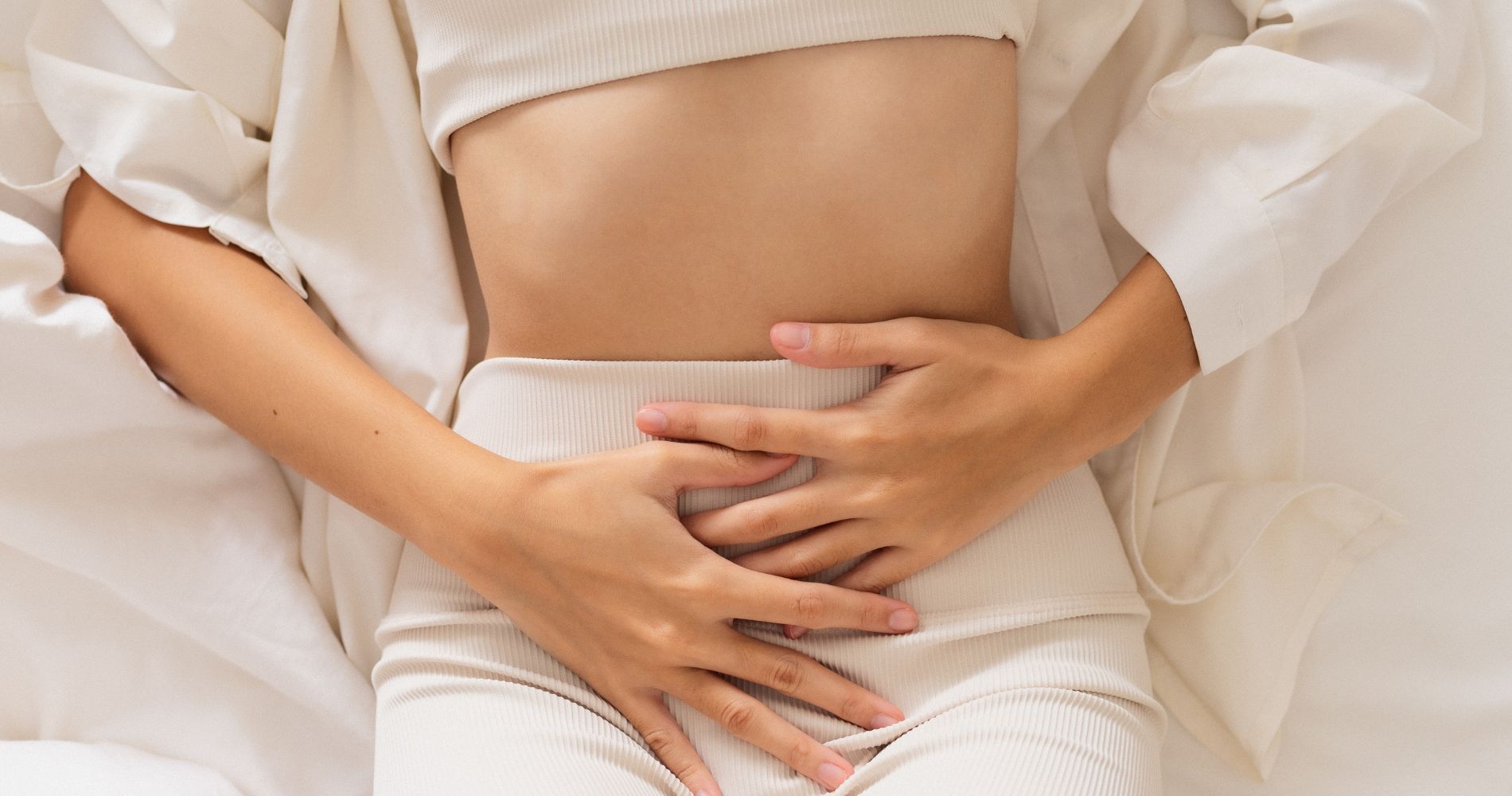 Kobieta trzymająca się za brzuch – ból związany z endometriozą.