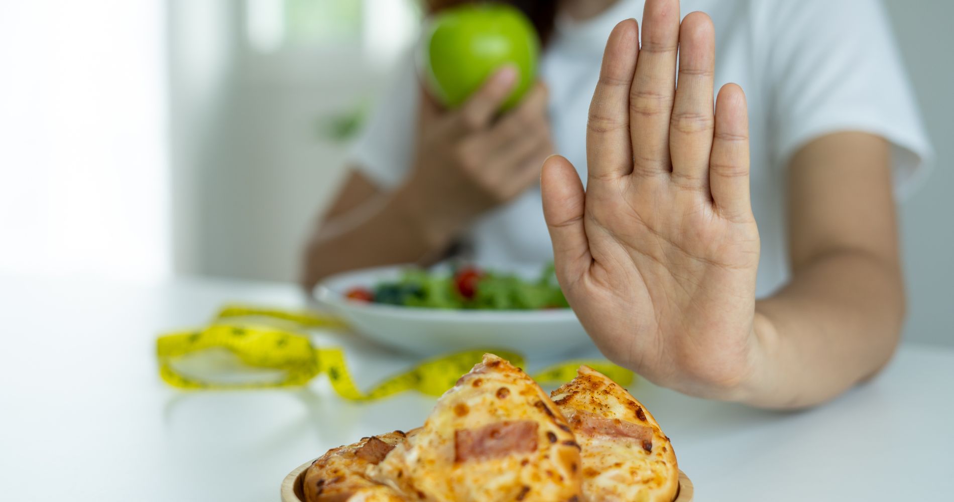 Osoba odmawiająca fast foodu i wybierająca zdrowe jedzenie, symbol odkwaszania organizmu i równowagi pH.