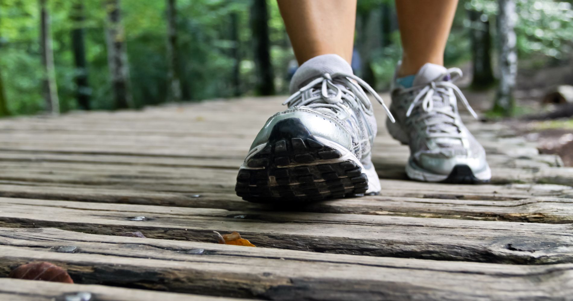 Zbliżenie na buty podczas chodzenia w lesie – codzienny spacer godzinny dla zdrowia.