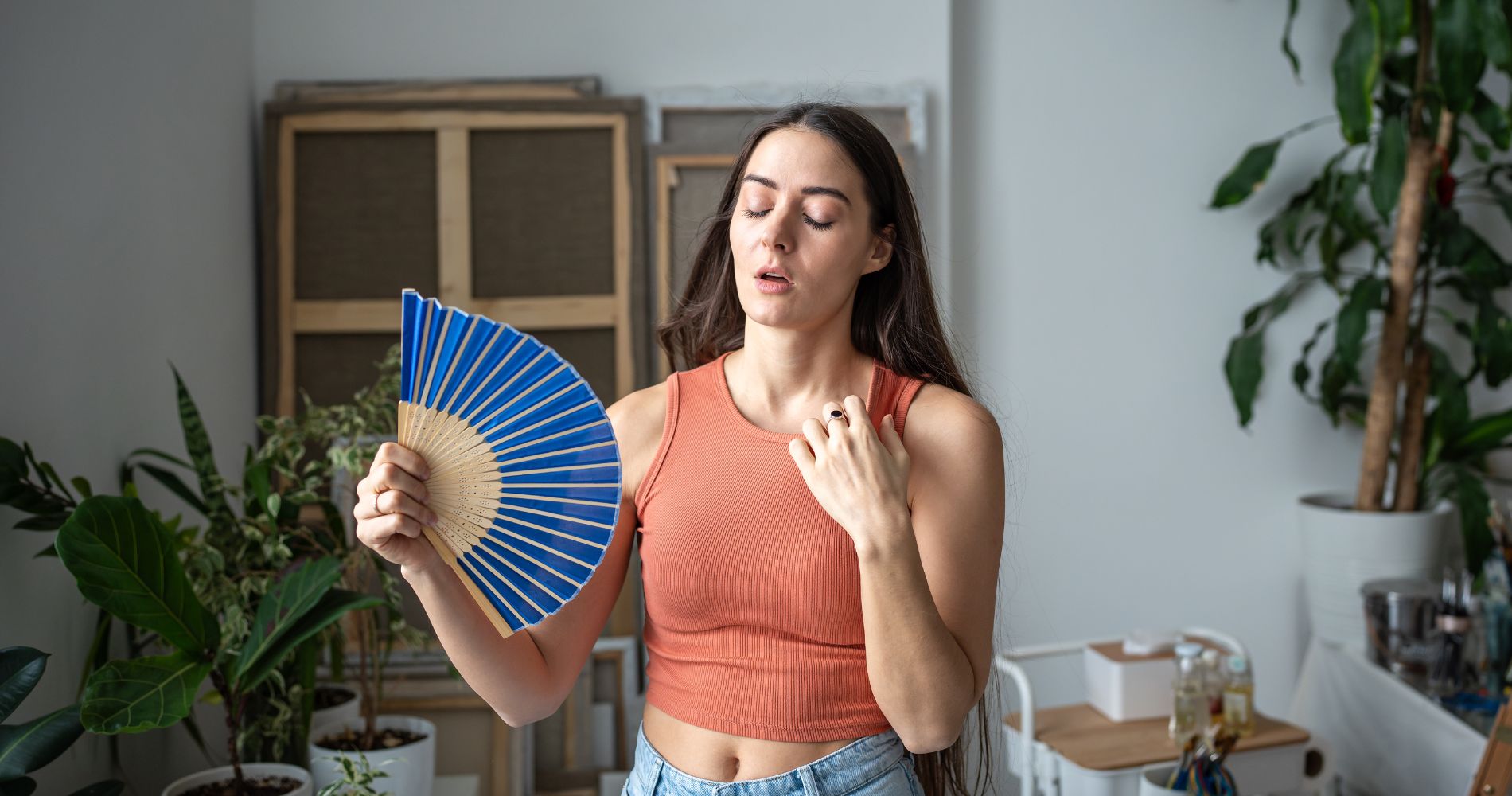Kobieta wachlująca się w upale – objawy przegrzania sprzyjają powstawaniu potówek.