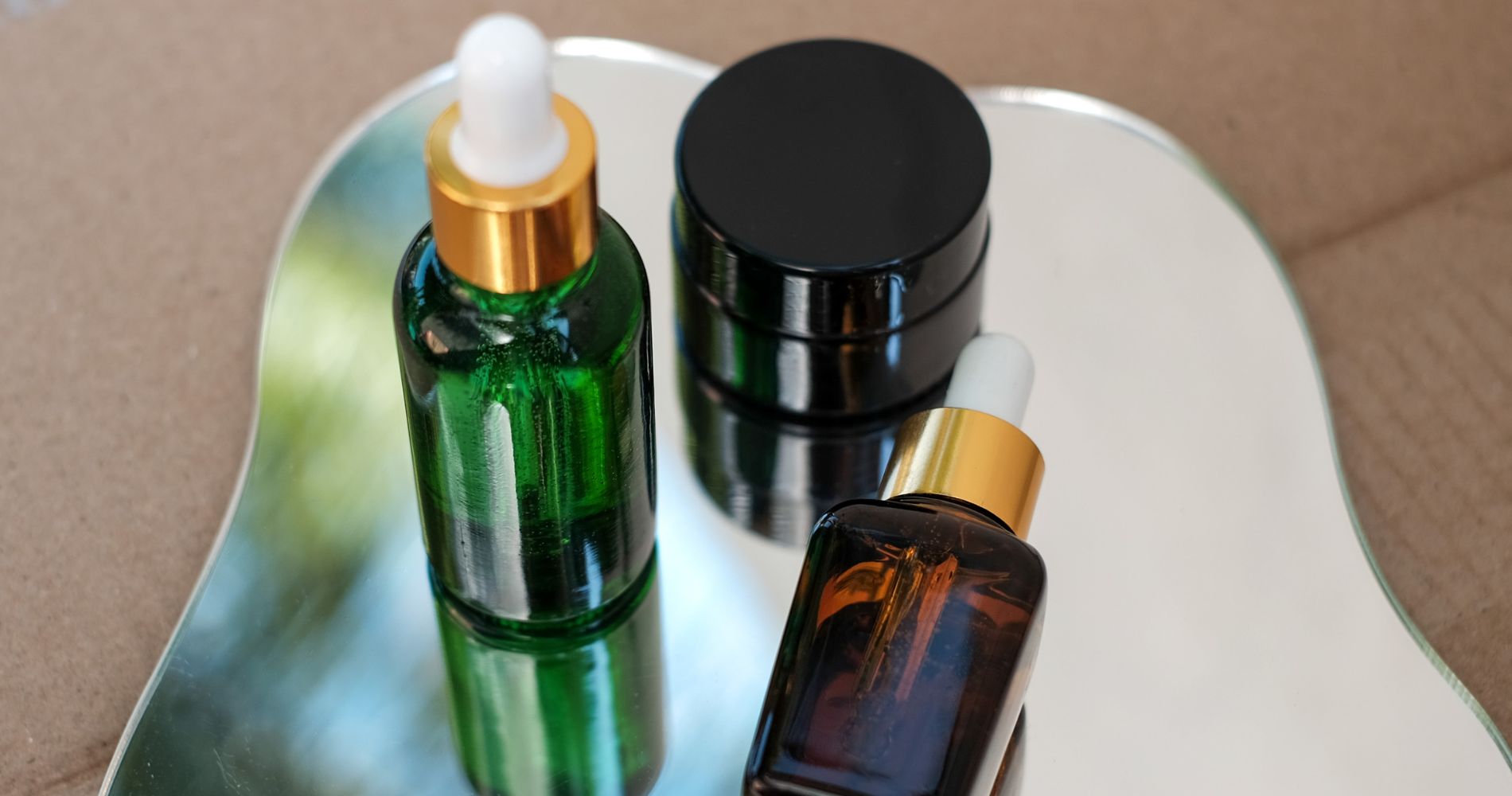 Kosmetyki w szklanych opakowaniach z pipetą – przykłady produktów z czytelnym oznaczeniem.
